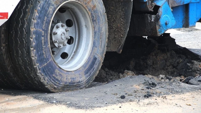 Asfalto cede e caminhão de lixo afunda em avenida 