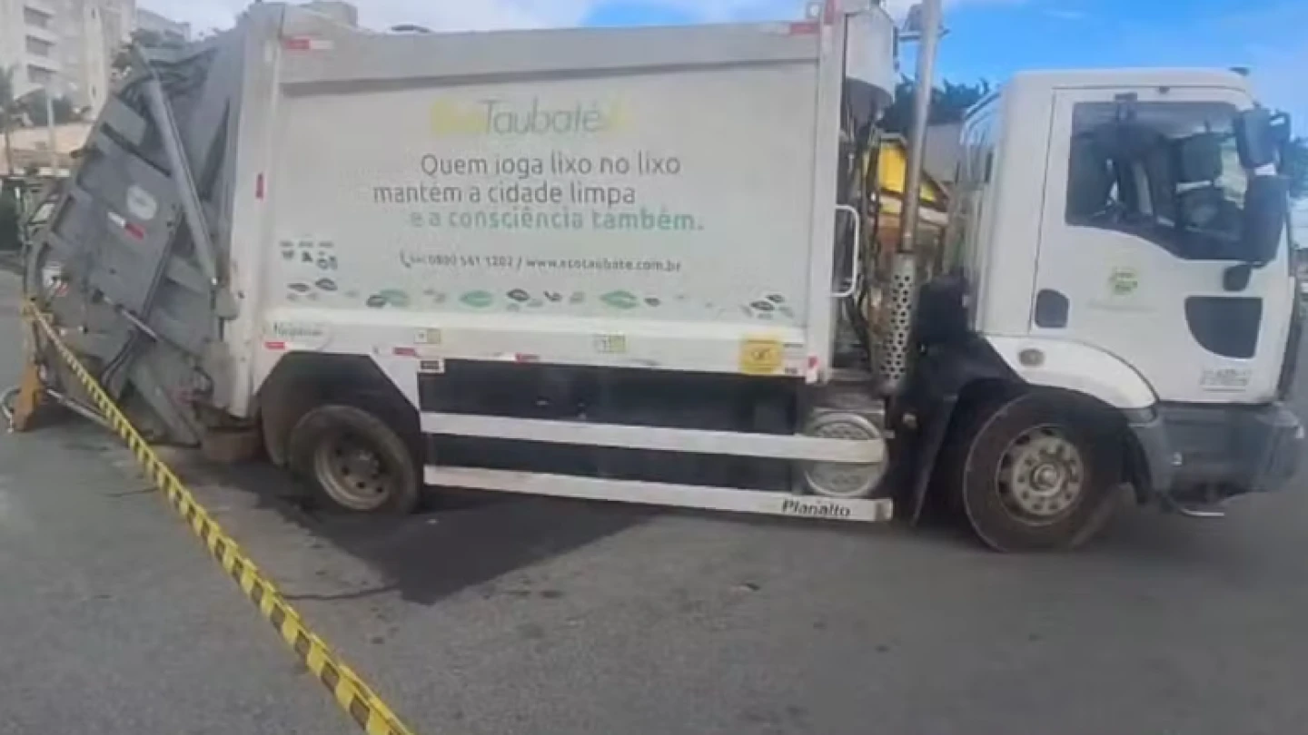 Caminhão de coleta de lixo fica preso em buraco, em Taubaté